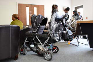 Mothers with pushchairs in clinic waiting room